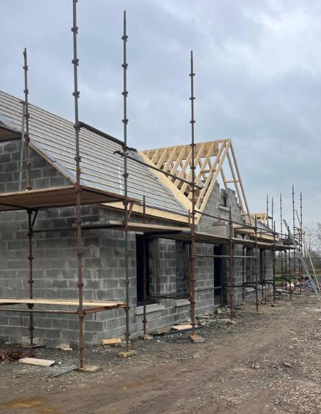 New build house with roof trusses and roof tiles being installed